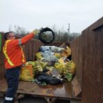 PW Manager Brad Thake throwing the broken tire into the dumpster