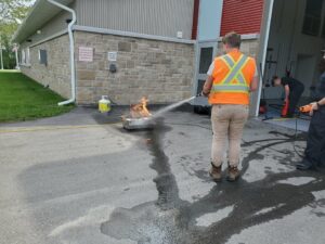 public works employee using fire extinguisher