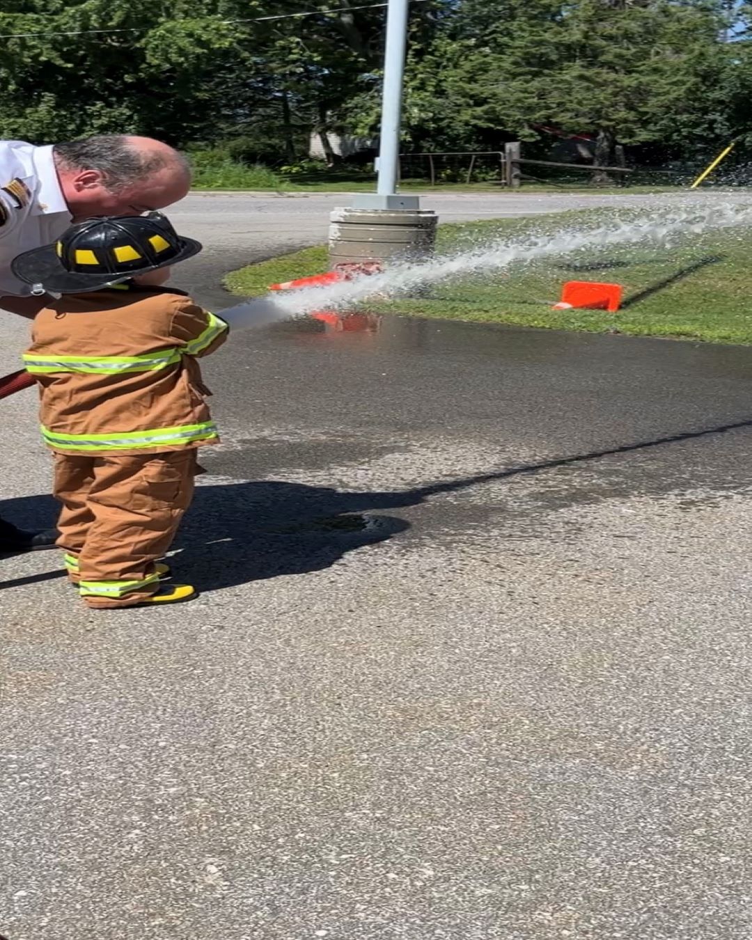 Fire Chief Rob Bowman, Connor (fire chief for the day) using a fire hose