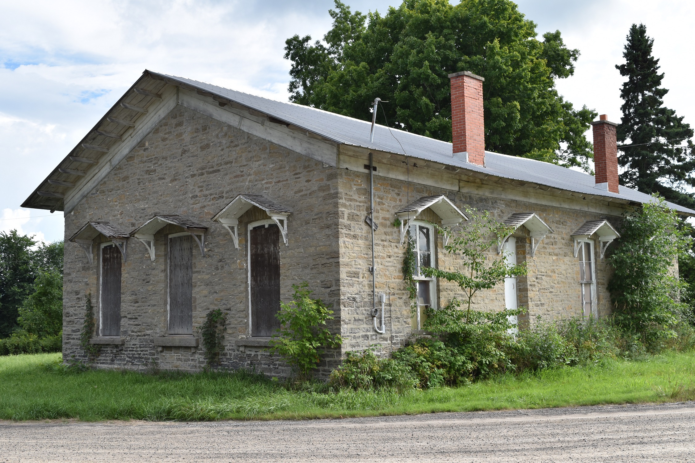 photo of an old stone building with 5 big windows and a door