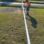 new flagpole being painted white by township staff
