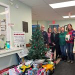 Giving tree with gifts and staff members from Augusta Township and Big Brothers Big Sisters of Leeds and Grenville