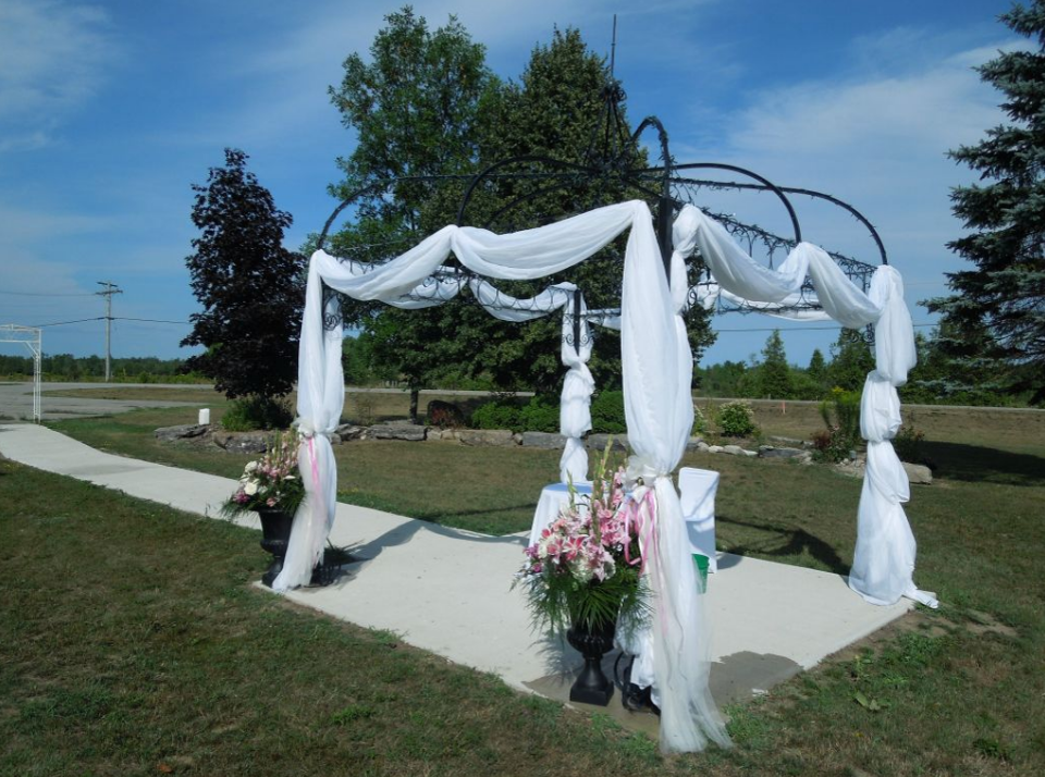 outdoor archway decorated with tulle and flowers